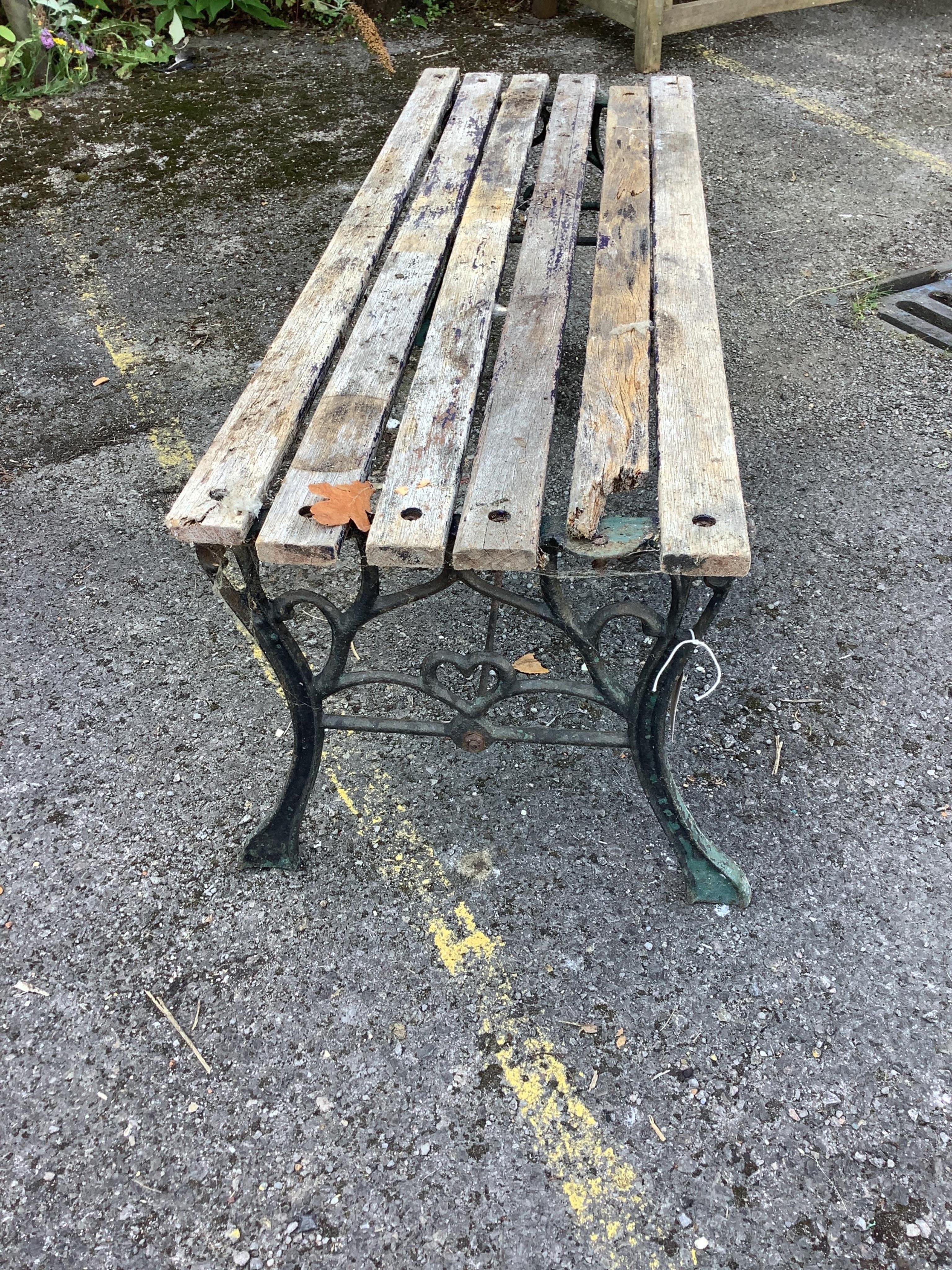 A Victorian slatted wooden bench with black painted aluminium end supports, height 40cm. (a.f.). Condition - poor